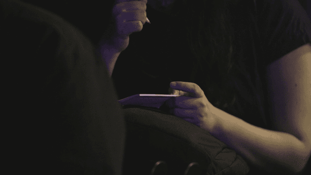 Person writing notes in a dimly lit room