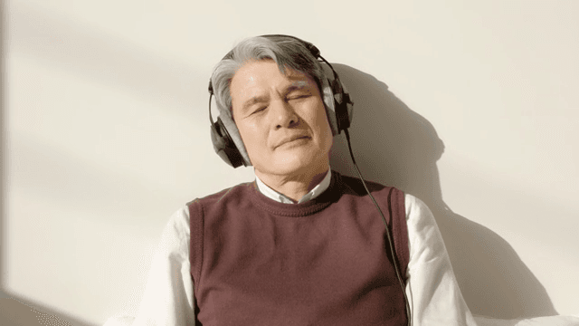 Elderly man enjoying music with headphones