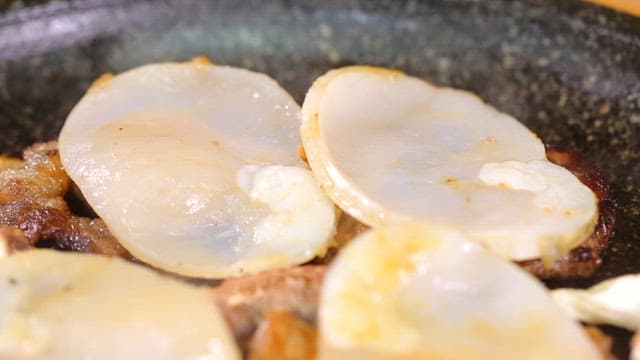 Beef, shiitake mushrooms and scallops sizzling on a grill