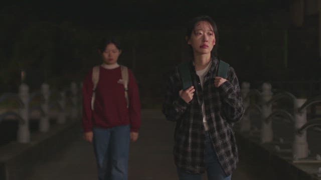 밤에 길을 걷는 얼굴에 상처가 난 여자와 그 뒤를 따라 걷는 여자