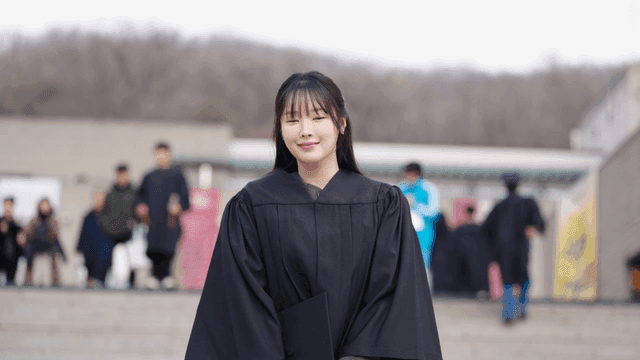 Smiling graduates wearing graduation gowns