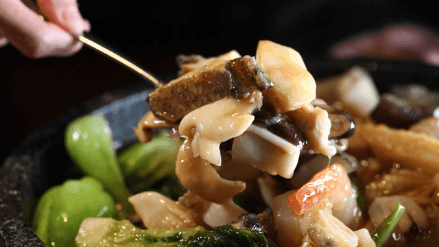 Spoonful of delicious seafood and vegetable Jeonbok