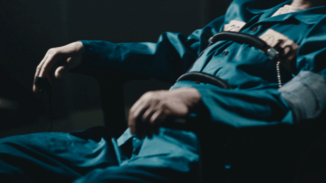 Prisoner being examined by lie detector in dark room