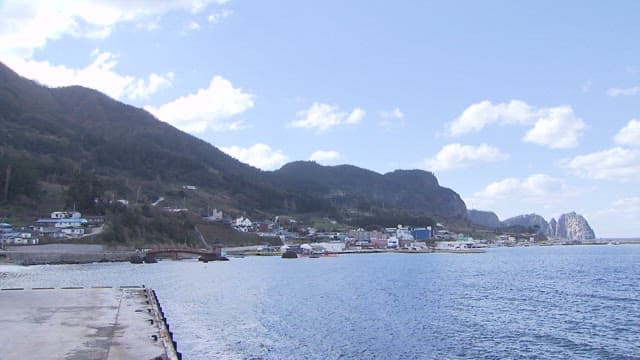 Coastal Village with a Mountain and Serene Sea