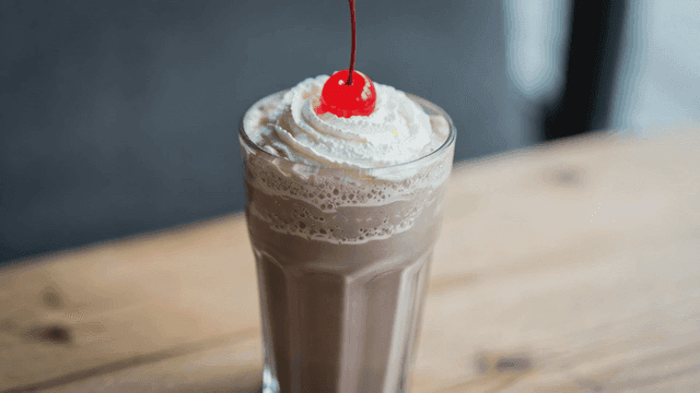 Chocolate milkshake with whipped cream and cherry