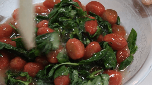 그릇에 신선한 토마토와 채소를 섞는 장면