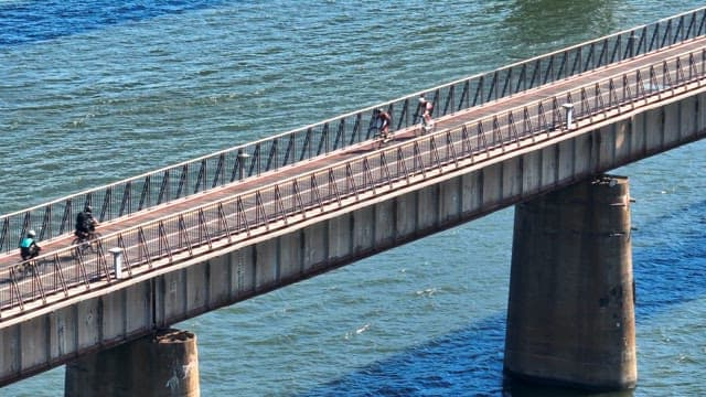 People riding bicycles on the bridge