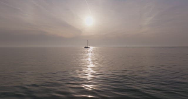 Yacht sailing on a calm sea at sunset