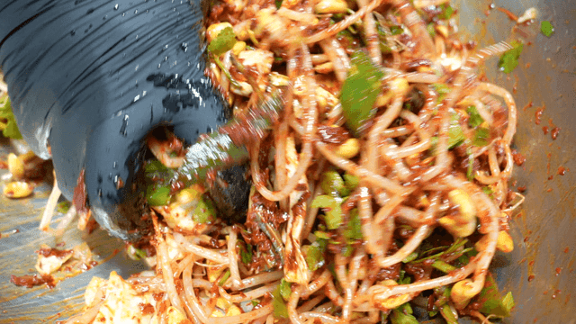 Mixing seasoned bean sprouts in a bowl