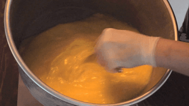 Chef mixing egg mixture in large pot with chopsticks