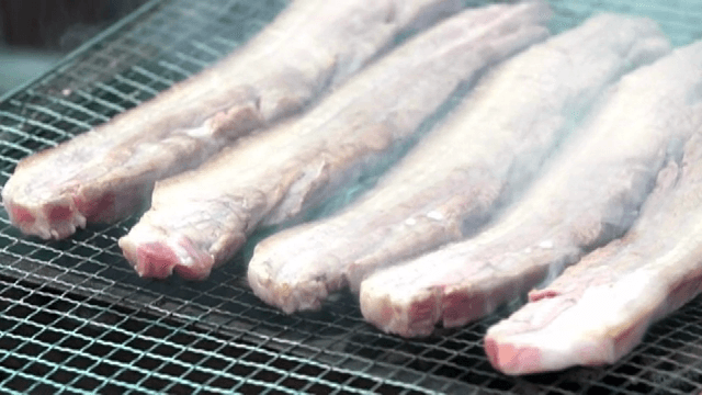 Pork belly grilling on a barbecue