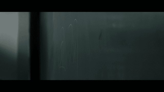 hand writing on a chalkboard in a classroom