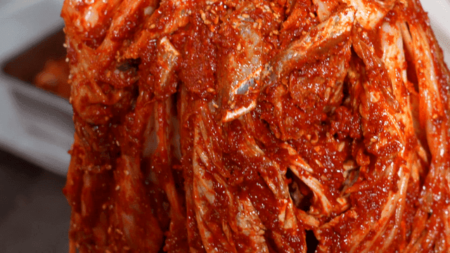 Kimchi being prepared with spices