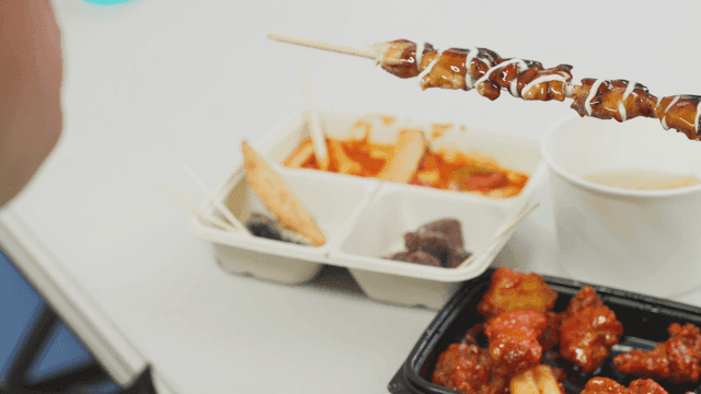 데리야끼 닭꼬치를 뜯어 먹는 사람