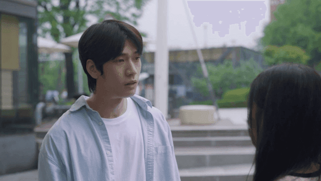 Man talking to woman in rainy park