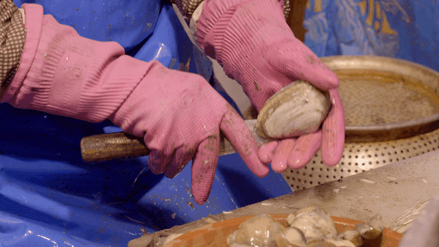 Person who shucks clams with knife