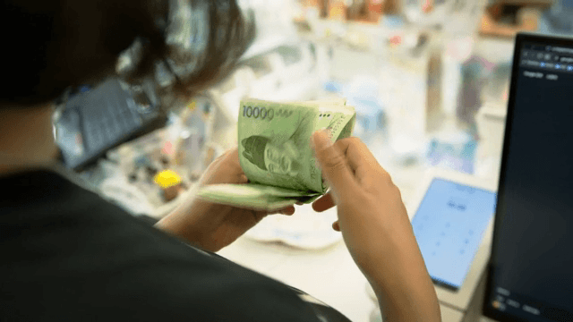 가게에서 한국 지폐를 세는 모습