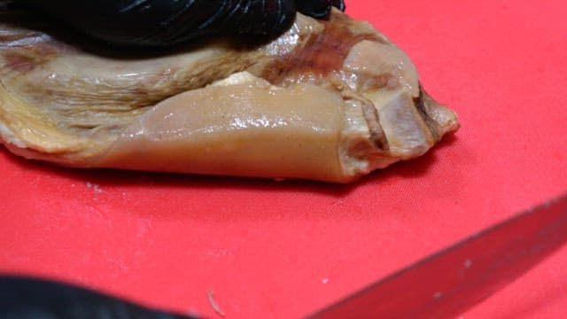 익힌 갈비를 빨간 도마 위에서 정성껏 써는 모습