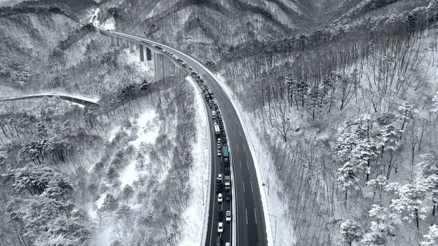 산을 가로지르는 눈 덮인 꽉 막힌 고속도로