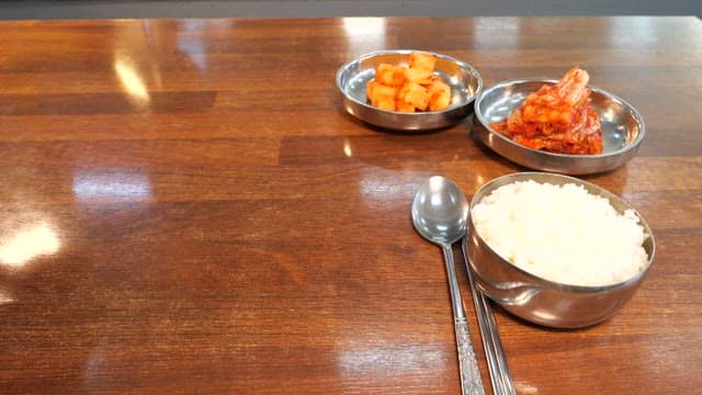 밥과 반찬이 있는 테이블에 서빙되는 순두부찌개