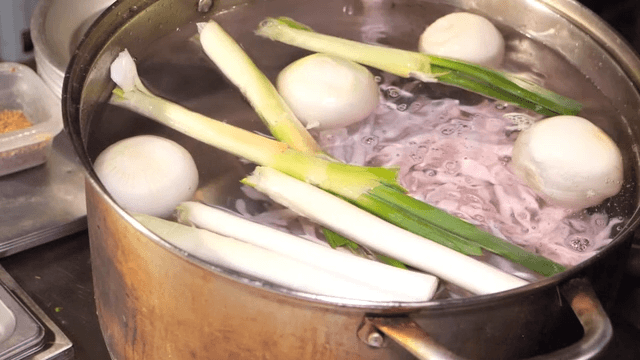 Chicken feet and vegetables in boiling pot