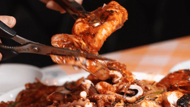 Spicy squid seafood stew cut with scissors