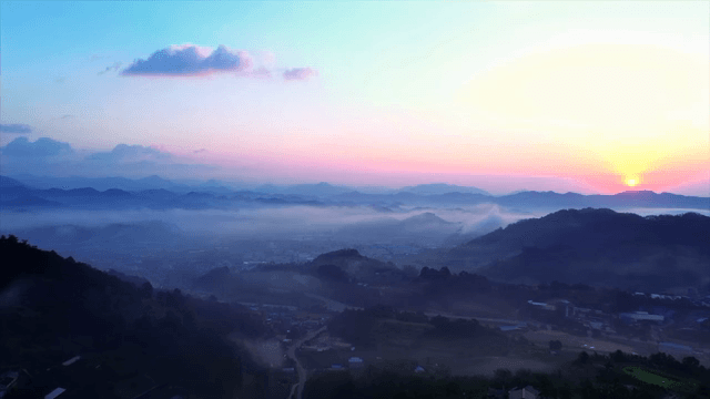 안개 낀 언덕과 함께하는 고요한 마을의 일출