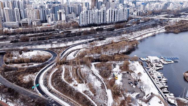 Snow-covered cityscape with river and roads