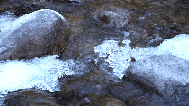 얼음과 바위가 있는 흐르는 시냇물