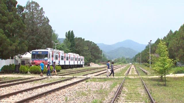 People walking by parked trains in Gudun Station