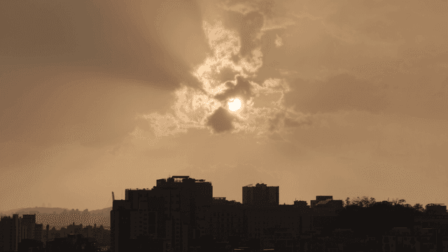 구름이 있는 도시 스카이라인 위의 일몰