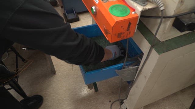 Worker handling metal parts in a factory