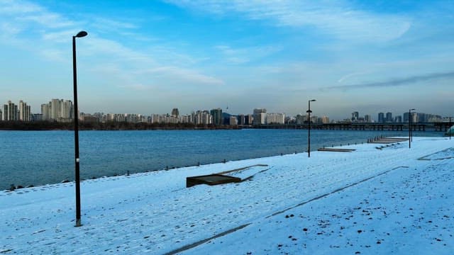 Snowy Riverfront with City Skyline