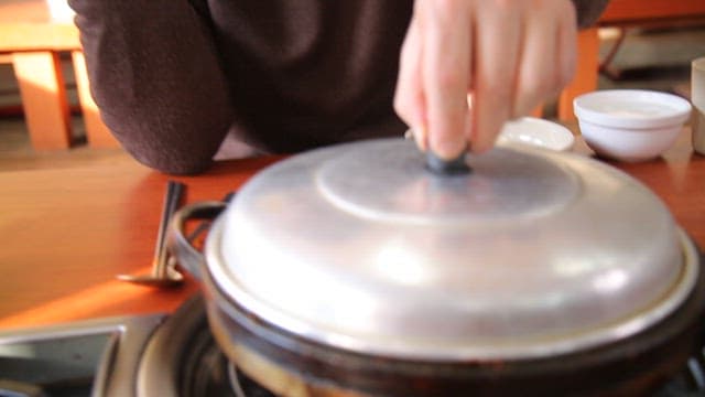 Spicy seasoned braised octopus cooking on a hot plate