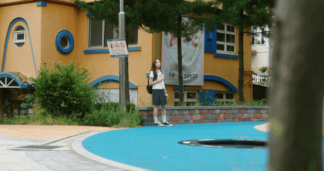 알록달록한 건물 밖에 서 있는 학생