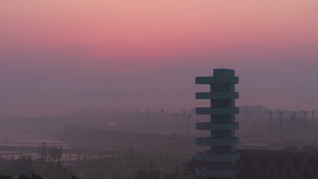 Modern tower against a pink sunset sky