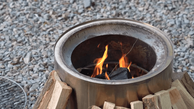 A campfire burning in a metal fire pit
