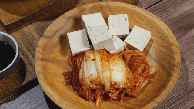 Kimchi and tofu on a wooden plate