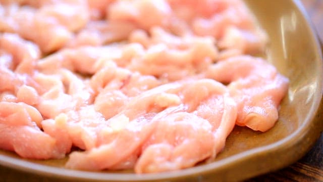 Raw chicken slices on a plate