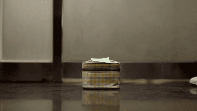 바닥에 놓여진 도시락통을 줍는 남성