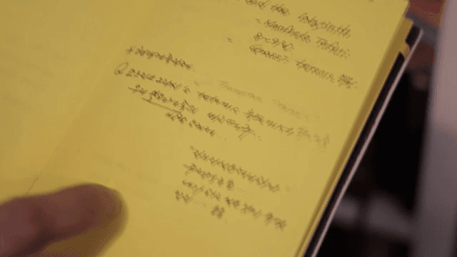 노란색 노트를 넘기는 손