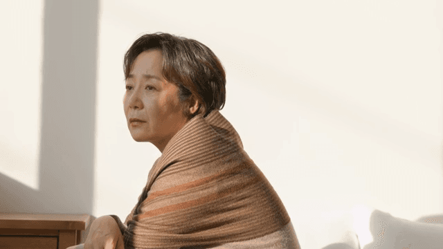 햇빛이 비치는 침대에 앉아 있는 여성