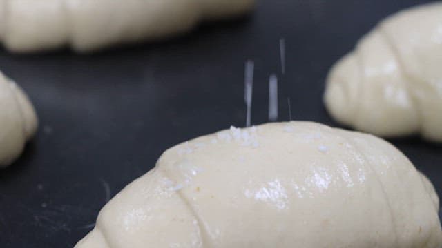 위에 소금이 뿌려진 소금빵 반죽