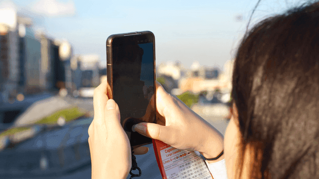 Person taking a photo of city buildings