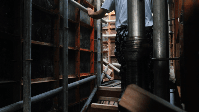 Worker navigating through scaffolding