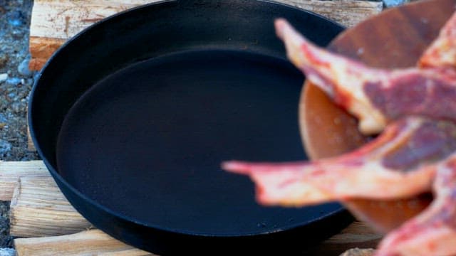 Well-seasoned lamb arranged neatly on a frying pan