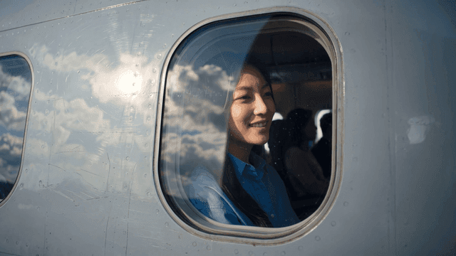 Woman smiling while looking out airplane window
