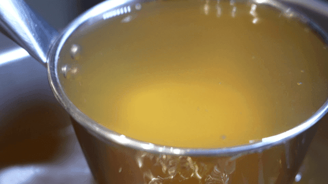 Stock mixed with ladle in pot