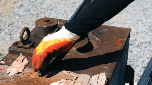 Worker using a machine to bend metal rods