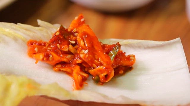 Kimchi and boiled pork on a cabbage leaf